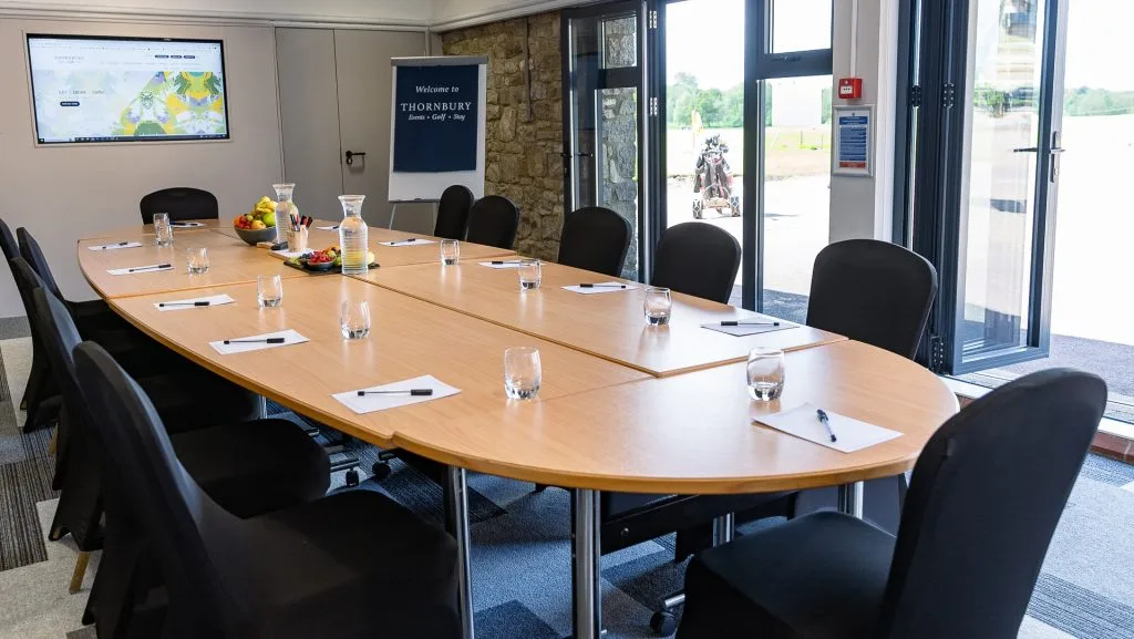 meeting room table with water and branded notepads at a business meeting venue in bristol