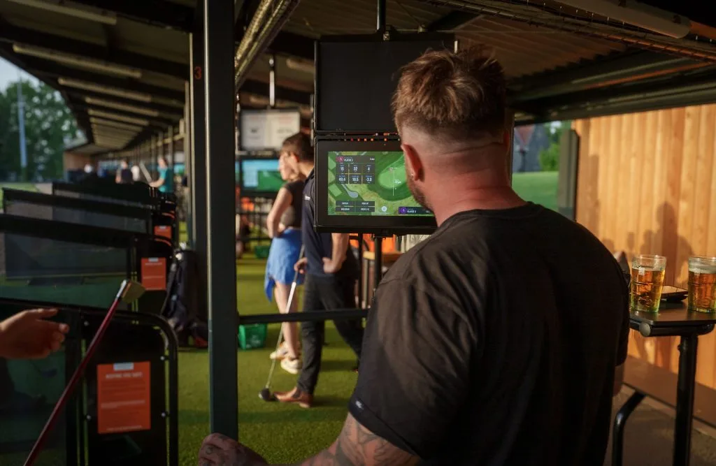golfer looking at monitor after shot at driving range in bristol