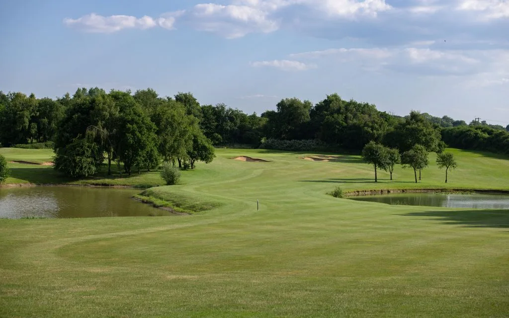 Golf fairway flanked by water on both sides at a golf course in Bristol.