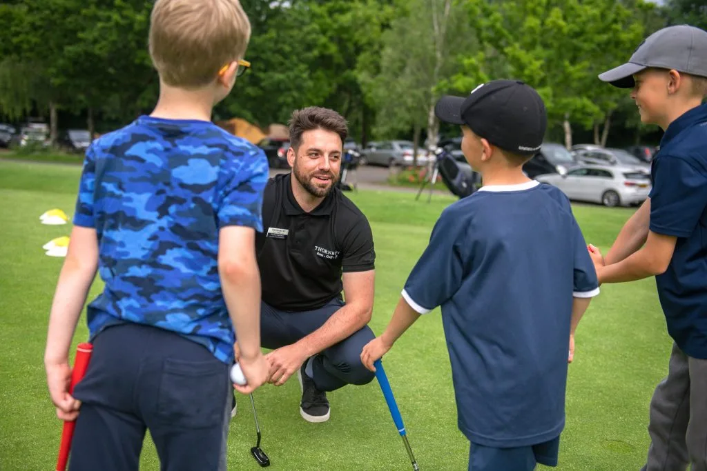 kids smiling with golf coach during junior golf lesson in bristol